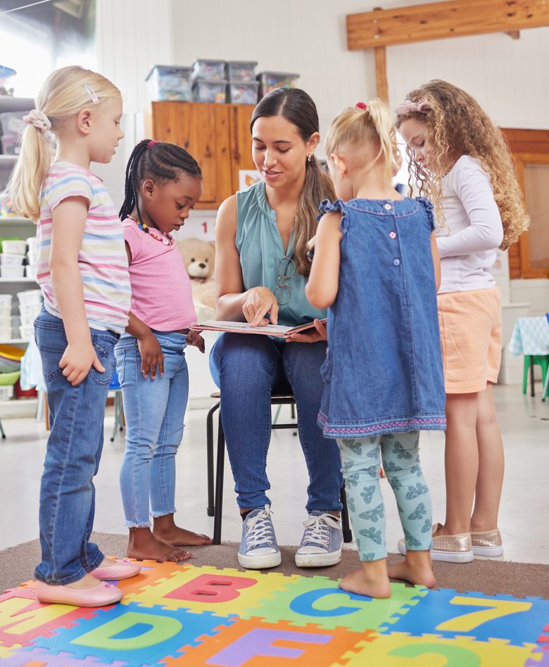 A teacher reading a picture book to a group of young children