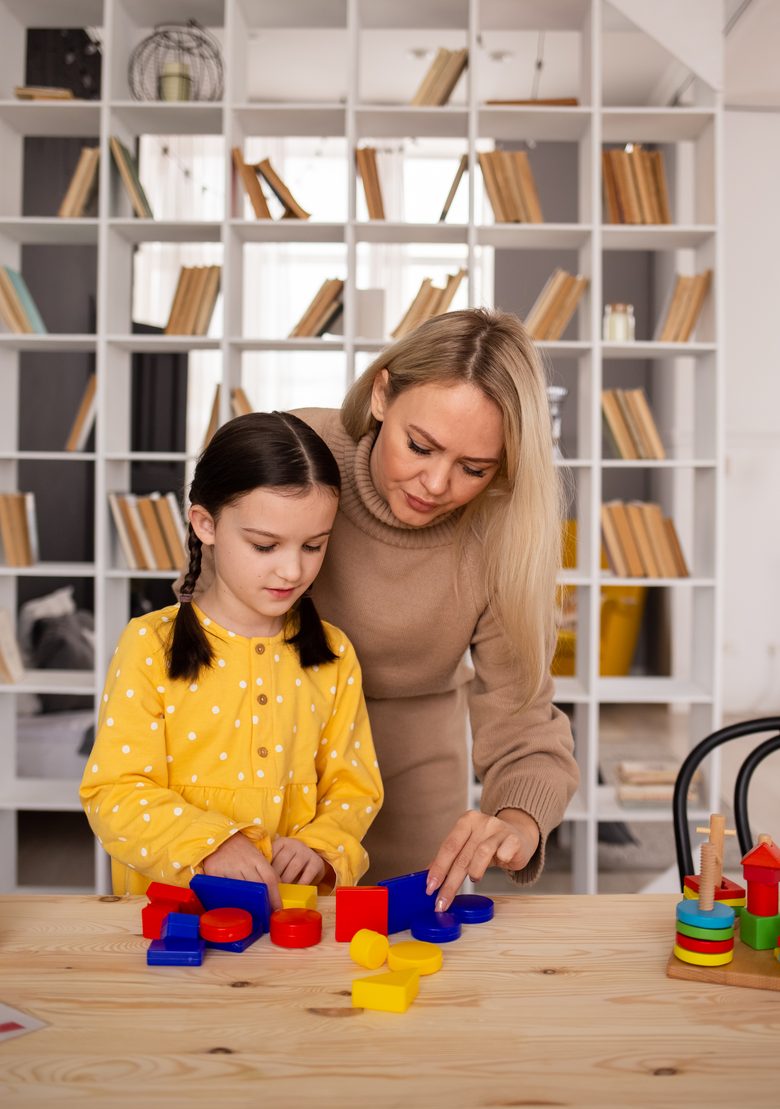 A mother and daughter sorting colorful wooden shapes together