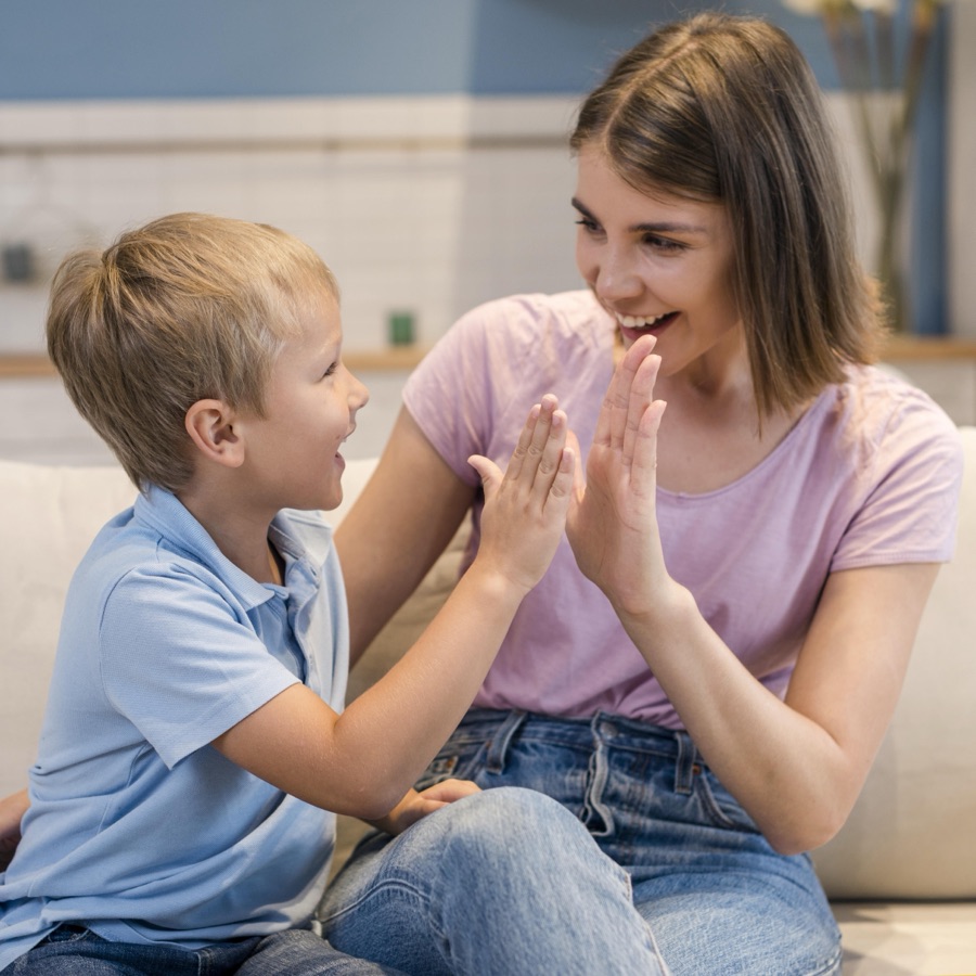 A Blue Jay ABA therapist sharing a high-five with a child