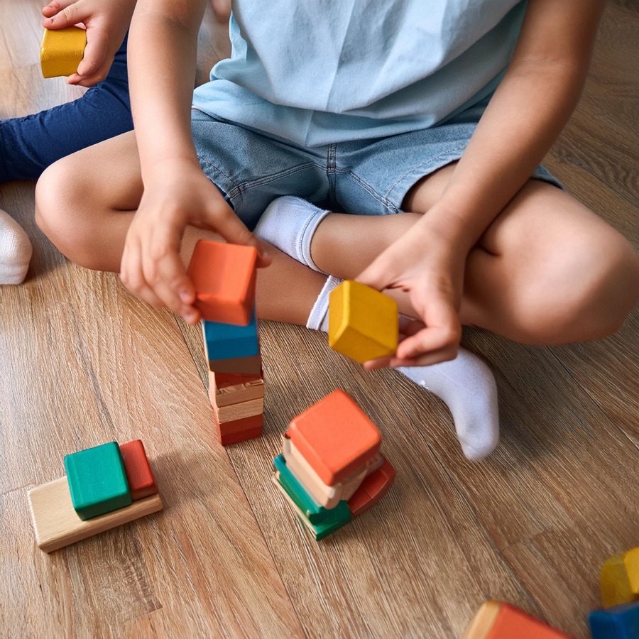 A child joyfully playing with wooden blocks