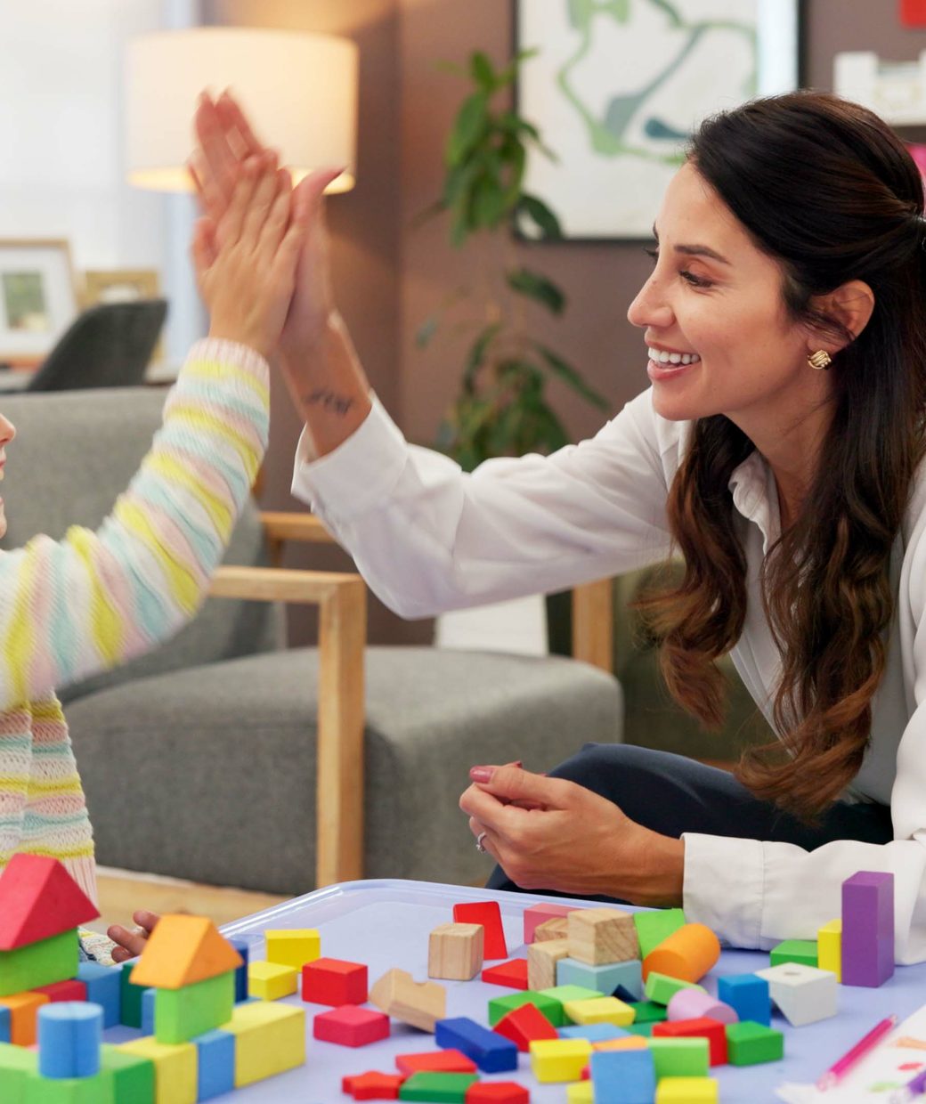 A clinician celebrating a calm moment with a child at home