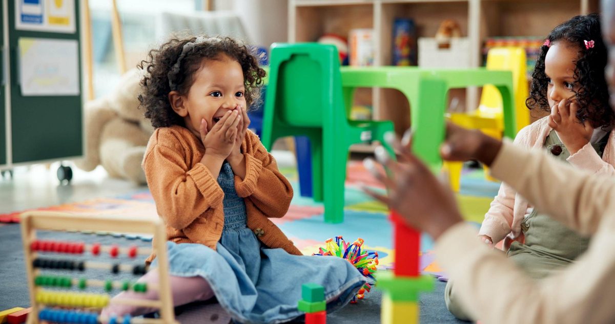 A delighted child playing with toys in a colorful classroom